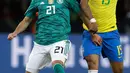 Pemain timnas  Jerman, Ilkay Gundogan berebut bola dengan pemain timnas Brasil, Paulinho dalam laga uji coba di Olympiastadion Berlin, Selasa (27/3). Brasil sukses menaklukkan Jerman dengan skor 1-0. (AP Photo/Michael Sohn)