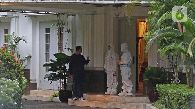 Gubernur DKI Jakarta Anies Baswedan berbincang dengan tim medis di rumah dinas Jalan Suropati, Menteng, Jakarta Pusat, Kamis (3/12/2020). Anies Baswedan melakukan isolasi mandiri di rumah dinas gubernur karena positif Covid-19 selama 14 hari ke depan. (Liputan6.com/Herman Zakharia)