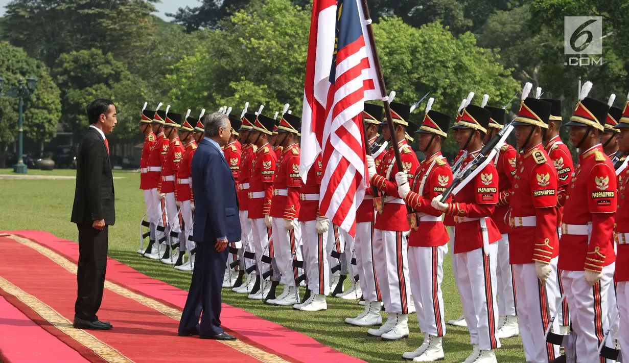 Presiden Joko Widodo bersama PM Malaysia, Mahathir Mohamad memeriksa pasukan saat kunjungan kenegaraan di Istana Bogor, Jumat (29/6). Indonesia menjadi negara pertama yang dikunjungi secara resmi oleh PM Mahathir usai dilantik. (Liputan6.com/Angga Yuniar)