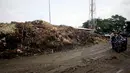 Warga saat melintas di dekat gunungan sampah di Pasar Induk Kramat Jati, Jakarta, Kamis (8/1/2015). (Liputan6.com/Faizal Fanani)