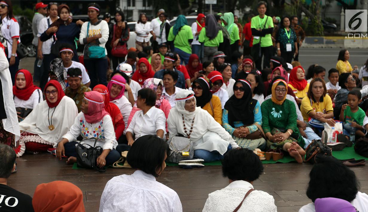 Relawan Indonesia Bersatu saat menggelar aksi potong tumpeng di depan Istana Negara, Jakarta, Jumat (5/7/2019). Aksi tersebut merupakan syukuran atas terpilihnya Joko Widodo atau Jokowi sebagai Presiden RI untuk kedua kalinya. (Liputan6.com/JohanTallo)