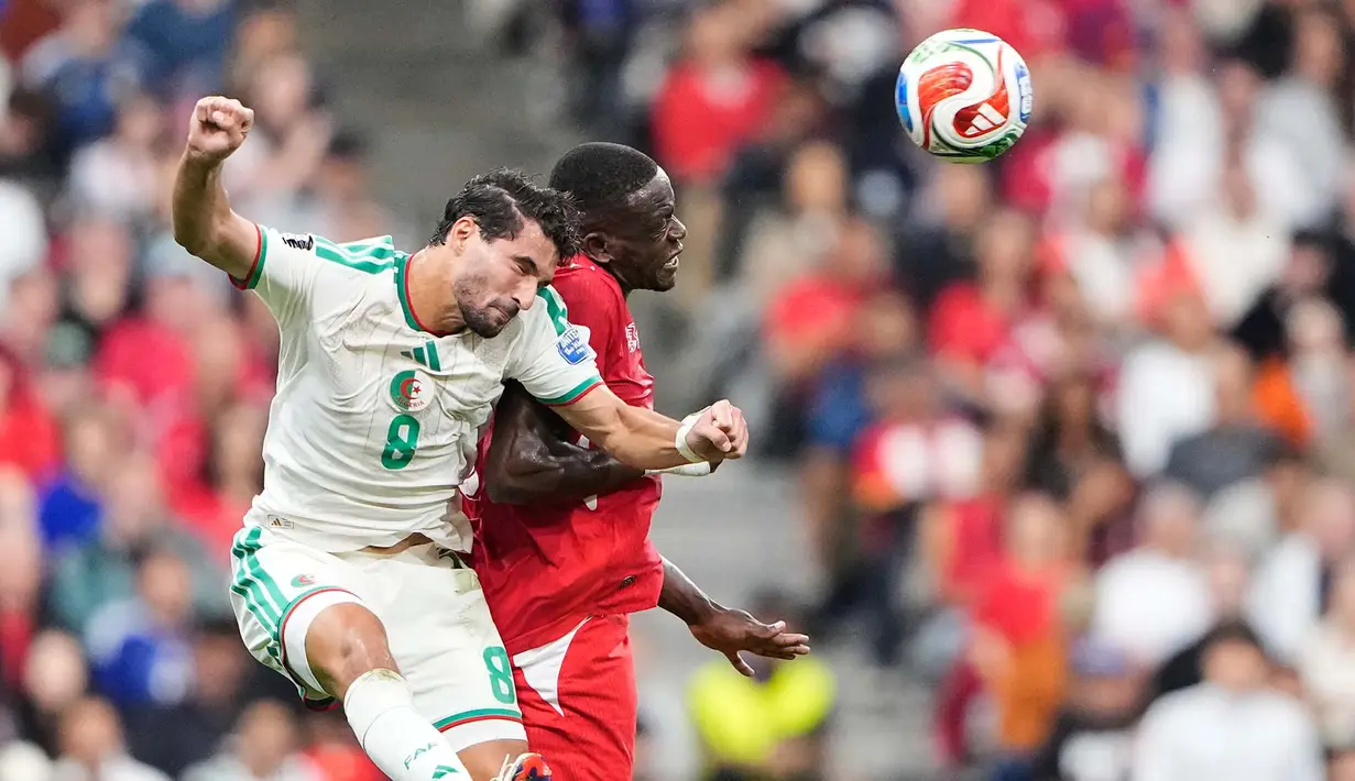 Pemain Aljazair Houssem Aouar  berebut bola atas dengan pemain Swiss Denis Zakaria dari Swiss selama pertandingan sepak bola babak 32 besar Piala Dunia antara Swiss dan Aljazair di Vancouver, British Columbia, Kamis, (02/07/2026). (AP Photo/Lindsey Wasson)