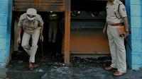 Polisi India mengecek restoran yang terbakar di Bangalore (8/1). Lima pekerja restoran tewas akibat kebakaran tersebut. Menurut Polisi, kurang dari dua minggu kebakaran telah terjadi di restoran lain menewaskan 14 orang. (AFP Photo/Manjunath Kiran)