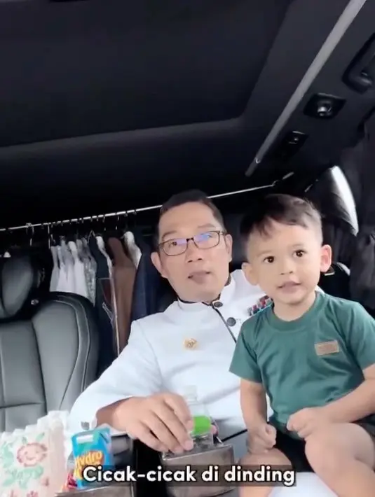 Masih mengenakan pakaian dinas, Ridwan Kamil memangku sang putra bungsu sambil mengajarinya bernyanyi. (Foto: Instagram/@ridwankamil)