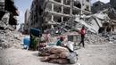 Warga Palestina duduk di dekat barang-barang mereka setelah mengunjungi rumah mereka yang hancur dalam serangan Israel di Khan Younis, Jalur Gaza, Rabu, 6 Maret 2024. (AP Photo/Mohammed Dahman)