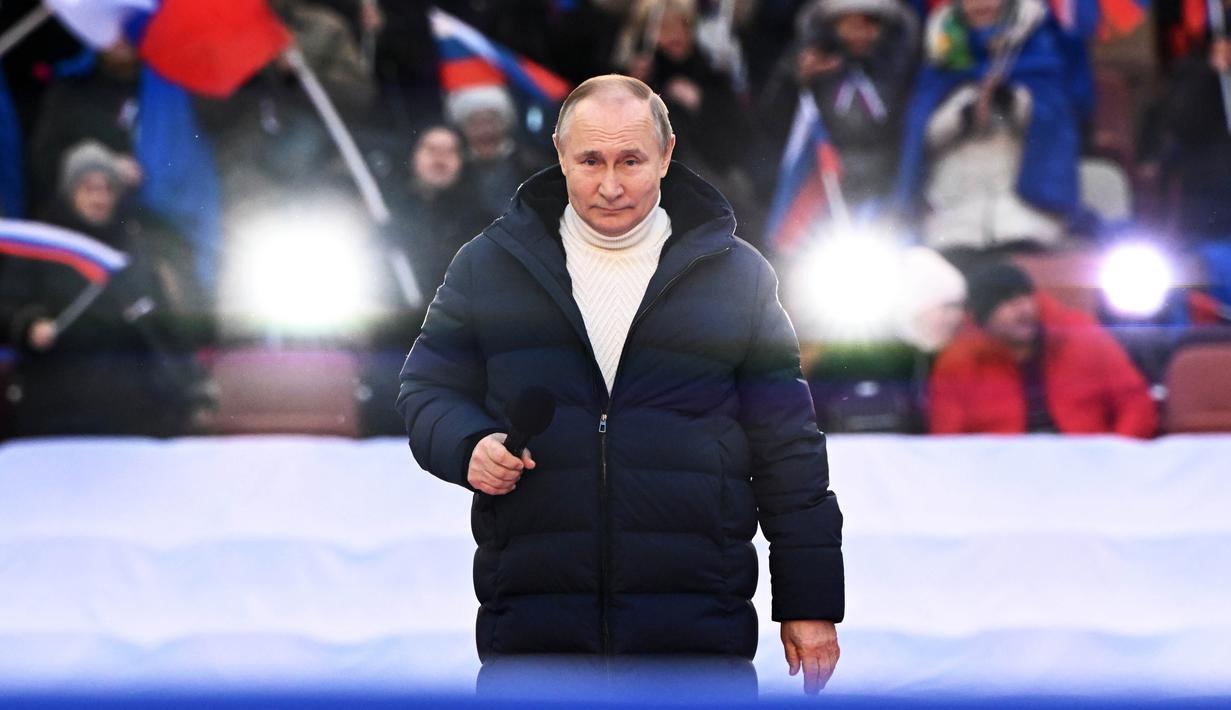 Presiden Rusia Vladimir Putin saat menyampaikan pidatonya pada konser perayaan  delapan tahun referendum tentang status negara bagian Krimea dan Sevastopol serta penyatuannya kembali dengan Rusia, di Moskow, Rusia (18/3/2022). (Sergei Guneyev/Sputnik Pool Photo via AP)