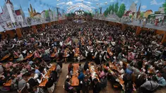 Pengunjung menikmati bir selama Festival Oktoberfest 2019 di sebuah tenda di Munich, Jerman selatan (3/10/2019). Festival bir terbesar di dunia Oktoberfest berlangsung hingga 6 Oktober 2019. (AFP Photo/Christof Stache)