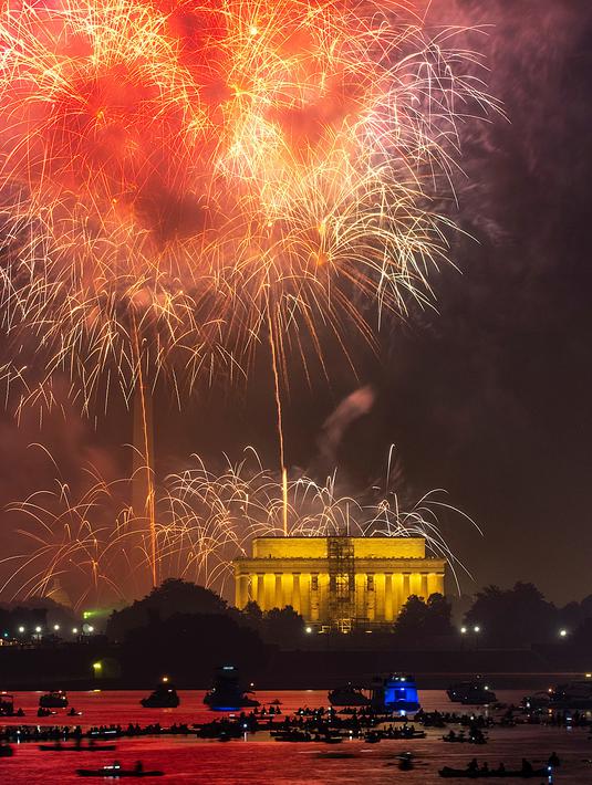 Warga dari atas kapal di Sungai Potomac menyaksikan pertunjukan kembang api pada perayaan Hari kemerdekaan Amerika di National Mall, Washington, Rabu (4/7). AS merayakan hari kemerdekaan pada 4 Juli atau dikenal Independence Day 4th July (AP/J. David Ake)