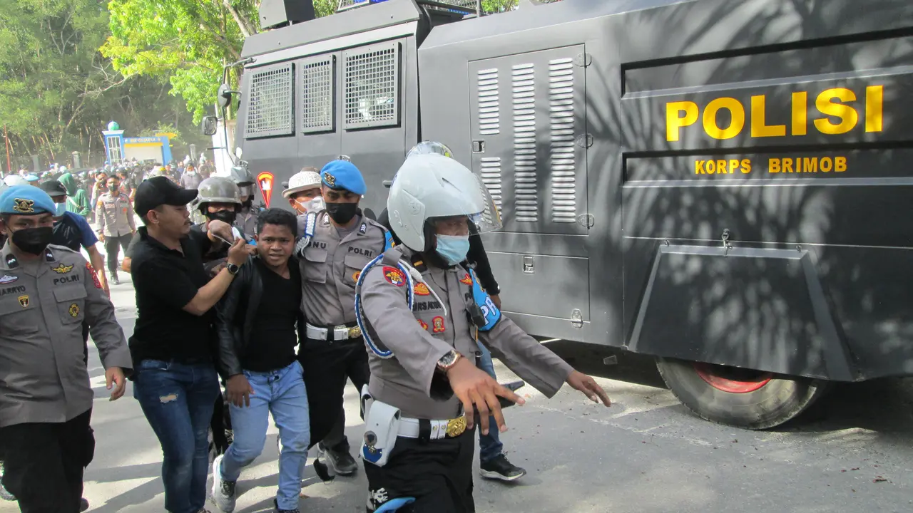 Polisi menangkap seorang peserta ketika terjadi bentrokan mahasiswa dan kepolisian saat demonstrasi mengusut tuntas kasus tewasnya Randi-Yusuf, Senin (27/9/2021).(Liputan6.com/Ahmad Akbar Fua)
