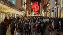 Orang-orang berjalan di sepanjang jalan komersial di pusat kota Madrid, Rabu (22/12/2021). PM Spanyol Pedro Sanchez mengadakan rapat Kabinet khusus untuk mengesahkan undang-undang yang mewajibkan penggunaan masker di luar ruangan di tengah lonjakan rekor kasus COVID-19. (AP Photo/Manu Fernandez)