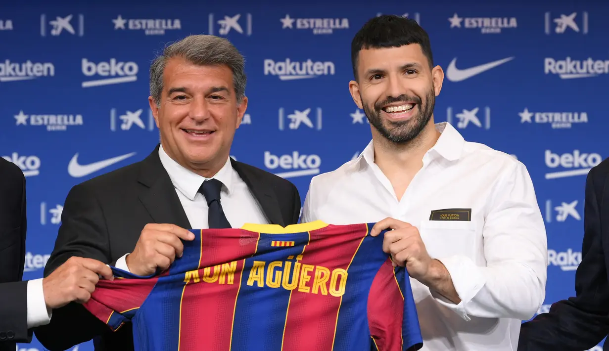 Penyerang Sergio Aguero (kanan) berpose dengan presiden Joan Laporta selama presentasi resminya sebagai pemain baru Barcelona di stadion Camp Nou, Spanyol (31/65/2021).  Barcelona dan Sergio Aguero sama-sama sepakat untuk menyelipkan klausul pelepasan dalam kontraknya. (AFP Photo/Lluis Gene)