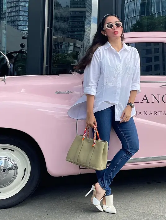 Tampil stunning dengan kacamata hitam yang bertengger di hidungnya, penampilan Ussy Sulistiawaty seperti anak usia 20-an tahun. Lengan kemeja yang dilipat hingga siku dan heels yang dkenakannya semakin mendukung penampilannya jadi makin keren. (Liputan6.com/IG/@ussypratama)
