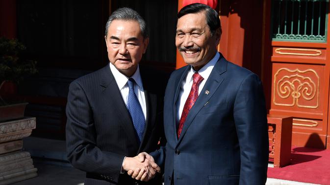 Menteri Luar Negeri China, Wang Yi berjabat tangan dengan Menko Kemaritiman Indonesia, Luhut Pandjaitan sebelum melakukan pertemuan di Wisma Negara Diaoyutai, Beijing. Rabu (24/10). (Daisuke Suzuki/Pool via AP)