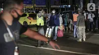 Sejumlah calon pemudik terjaring razia penyekatan di Pintu Tol Cikarang Barat, Bekasi, Jawa Barat, Sabtu (23/5/2020). Calon pemudik yang terjaring razia tersebut dibawa ke Terminal Pulogebang untuk kemudian diarahkan kembali menuju Jakarta. (Liputan6.com/Johan Tallo)