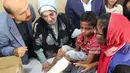 Ibu Negara Turki, Emine Erdogan dan putranya, Bilal melihat luka seorang muslim Rohingya yang melarikan diri dari Myamnar saat menyerahkan bantuan di kamp pengungsi Kutupalong, Bangladesh, Kamis (7/9). (Presidency Press Service via AP, Pool)