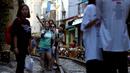 Foto pada 8 Juni 2019 memperlihatkan wisatawan berswafoto di tengah jalur kereta api populer di Hanoi. Turis sengaja datang ke Old Quarter untuk berfoto di rel kereta api yang dianggap ' instagramable' tersebut. (Photo by Manan VATSYAYANA / AFP)