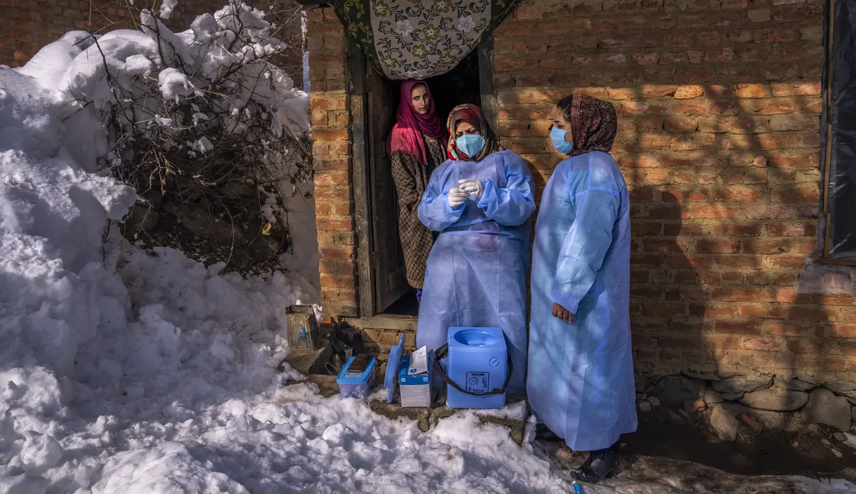 Fozia, seorang petugas kesehatan, menyiapkan vaksin COVID-19 Covishield sebelum diberikan kepada seorang perempuan lanjut usia selama upaya vaksinasi COVID-19 di Budgam, barat daya Srinagar, Kashmir yang dikuasai India, pada 11 Januari 2022. (AP Photo/Dar Yasin)