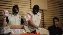 Penyidik KPK menunjukkan barang bukti disaksikan Pimpinan KPK Laode M Syarif dan Jubir  KPK Febri Diansyah saat memberikan keterangan Operasi Tangkap Tangan (OTT) Bupati Klaten di Gedung KPK, Jakarta, Sabtu (31/12). (Liputan6.com/Helmi Afandi)