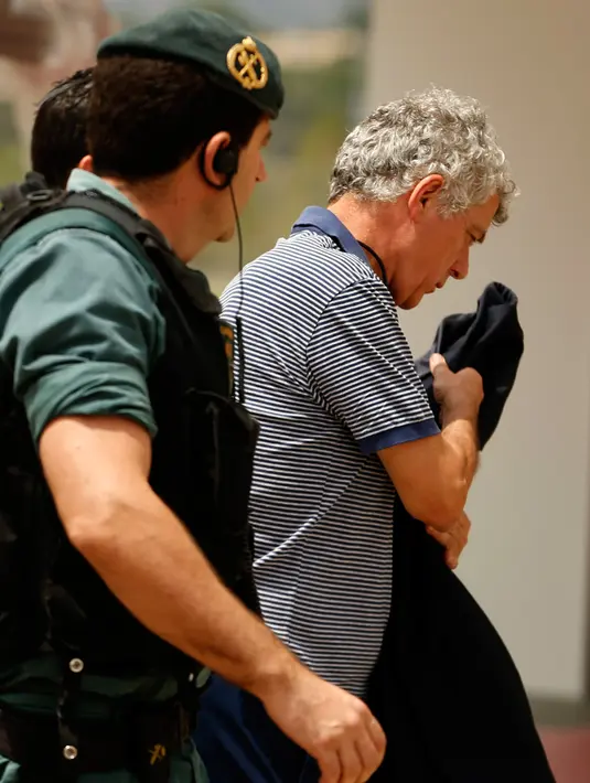Mantan Presiden RFEF, Angel Maria Villar dibawa oleh polisi Garda Sipil Spanyol menuju markas besar Federasi di Las Rozas, Spanyol (18/7). Selain Villar, Putranya dan Wakil Presiden RFEF juga terlibat kasus yang sama. (AP Photo / Francisco Seco)