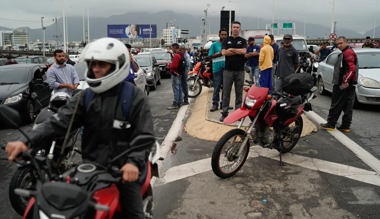 Sejumlah orang menunggu saat terjadi penyanderaan sebuah bus oleh pria bersenjata di jembatan yang menghubungkan Kota Niteroi dengan Rio de Janeiro, Brasil, Selasa (20/8/2019). Lalu lintas diblokir di kedua arah di jembatan tersebut, mengakibatkan ratusan kendaraan mengantre. (AP Photo/Leo Correa)