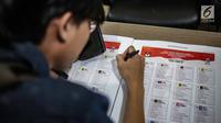 Petugas memeriksa contoh surat suara Pemilu 2019 di Kantor Komisi Pemilihan Umum (KPU), Jakarta, Kamis (13/12). Proses validasi ini berlangsung hingga 17 Desember 2018. (Liputan6.com/Faizal Fanani)