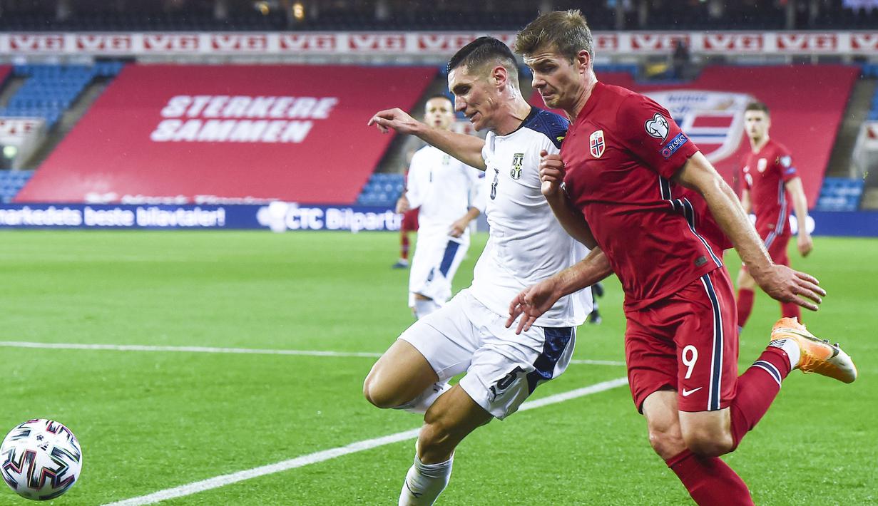 Penyerang Serbia, Aleksandar Mitrovic, berebut bola dengan penyerang Norwegia, Alexander Sorloth, pada laga semi final playoff Euro 2020 di Ullevaal Stadion, Jumat (9/10/2020) dini hari WIB. Serbia menang 2-1 atas Norwegia. (AFP/Fredrik Varfjell/NTB)