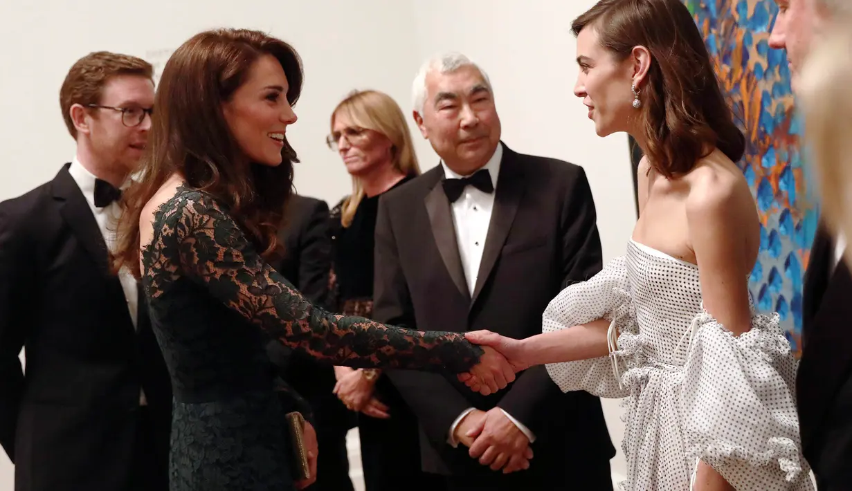 Duchess of Cambridge, Kate Middleton menyapa model Alexa Chung saat menghadiri pameran Portrait Gala 2017 dan penggalangan dana di National Portrait Gallery, London (28/3). (Neil Hall/Pool photo via AP)