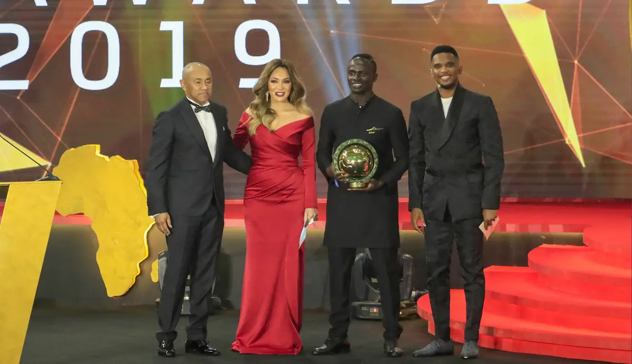 Penyerang Senegal, Sadio Mane (kedua kanan) foto bersama Presiden Konfederasi Sepak Bola Afrika, Ahmad Ahmad (kiri), Mantan striker Kamerun Samuel Eto'o (kanan) setelah memenangkan penghargaan Pemain Terbaik Afrika 2019 selama CAF Awards di kota wisata Mesir, Hurghada (7/1/2020). (AFP/Khaled Desouki