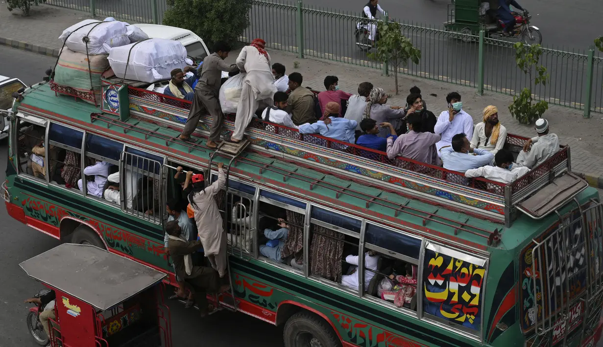 Warga berada di bus saat mereka melakukan perjalanan ke kampung halaman mereka menjelang perayaan Idul Fitri di Lahore (7/5/2021). Lebaran Idul Fitri jatuh pada 13 Mei 2021. (AFP Photo/Arif Ali)