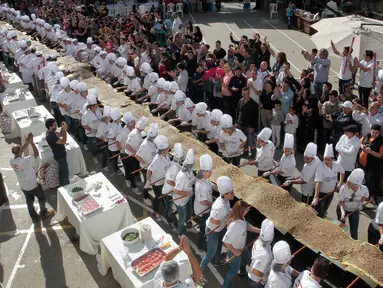 Peserta menyiapkan roti manousheh dengan rempah-rempah, wijen dan minyak zaitun, di Choueifat, Beirut, Lebanon (22/11). Roti sepanjang 32 meter ini disiapkan untuk memperingati Hari Kemerdekaan Lebanon dengan tujuan memecahkan rekor dunia. (AFP PHOTO/STR)
