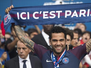 Mantan bek Juventus, Dani Alves, mengangkat syal saat diperkenalkan sebagai pemain baru PSG di Stadion Parc des Princes, Paris, Rabu (12/7/2017). (EPA/Ian Langsdon)