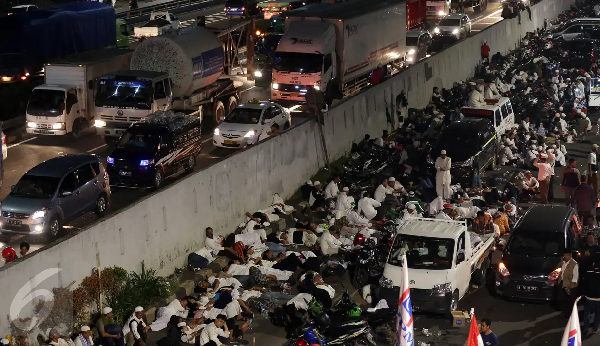 Massa peserta demo 4 November tidur di trotoar Jalan Gatot Subroto, Jakarta atau tepat di depan Gedung MPR/DPR RI, Jumat (4/11). Mereka terpaksa menginap di jalan depan Gedung DPR lantaran tak diizinkan masuk ke komplek parlemen (Liputan6.com/Johan Tallo)
