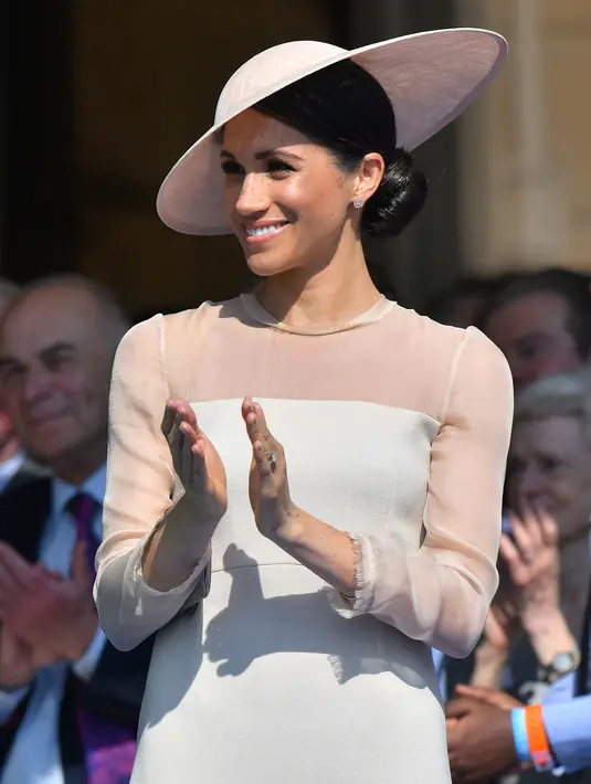 Duchess of Sussex, Meghan Markle menghadiri pesta kebun Istana Buckingham di London, Selasa (22/5). Meghan Markle mulai menunjukkan statement look dirinya dan menampilkan fashion ala kerajaan Inggris. (Dominic Lipinski/Pool Photo via AP)