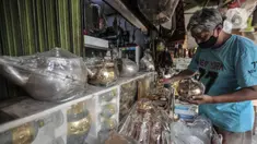 Budi (54) merapikan barang yang dijual di toko oleh-oleh haji di Jalan Raya Pondok Gede, Jakarta, Rabu (21/7/2021). Larangan ibadah haji dan umrah akibat pandemi di Indonesia menyebabkan penjualan oleh-oleh khas Makkah di depan Asrama Haji Pondok Gede merosot tajam. (merdeka.com/Iqbal S. Nugroho)