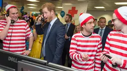 Ekspresi lucu Pangeran Harry saat ambil bagian menjadi broker dalam acara amal tahunan ICAP di London, Rabu (7/12). Pangeran Harry menjadi broker dadakan untuk mengumpulkan dana amal dari 60 kantor di seluruh dunia. (REUTERS/Geoff Pugh/Pool)