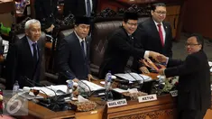 Perwakilan Pemerintah Menteri Keuangan Bambang Brodjonegoro (kanan) memberikan Laporan kepada Ketua Rapat, Wakil Ketua DPR Taufik Kurniawan dan Ketua DPR Ade Komarudin saat Rapat Paripurna di Jakarta, (25/7). (Liputan6.com/Johan Tallo)