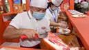 Para peserta pameran menyiapkan produk daging dalam Pameran Industri Daging Internasional China ke-18 di Qingdao, Provinsi Shandong, China, 10 September 2020. (Xinhua/Li Ziheng)