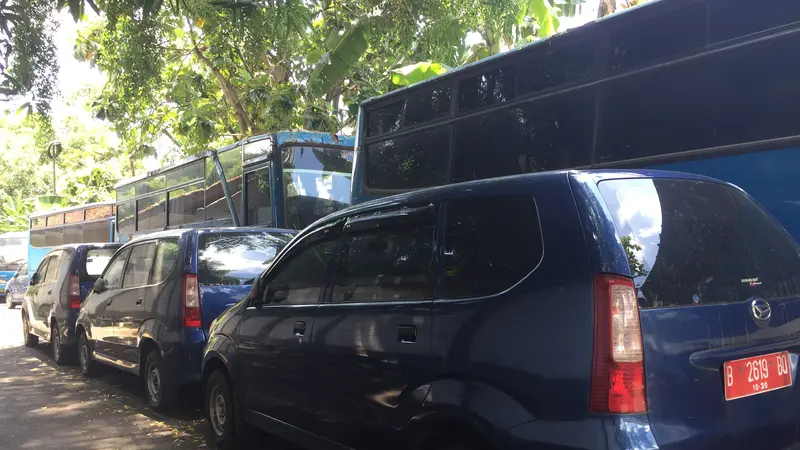 Puluhan mobil berpelat merah terparkir tanpa perawatan di halaman belakang Gedung DPR. (Liputan6.com/Devira Prastiwi)