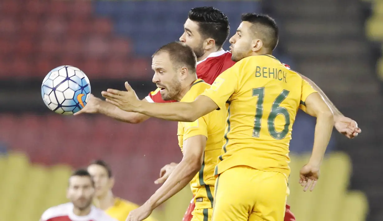 Pemain Australia, Aziz Behich, duel udara dengan pemain Suriah Omar Alsoma pada laga Kualifikasi Piala Dunia 2018 di Stadion Hang Jebat, Kamis (5/10/2017). Suriah bermain imbang 1-1 dengan Australia. (AP/Vincent Thian)