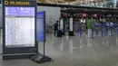 Penumpang melihat pemberitahuan informasi penerbangan setelah semua penerbangan dibatalkan di Bandara Internasional Pudong, Shanghai, Minggu (25/7/2021). China menutup jalur kereta api dan pelabuhan, serta membatalkan jadwal penerbangan sebelum topan In-Fa diperkirakan mendarat (AP Photo/Andy Wong)