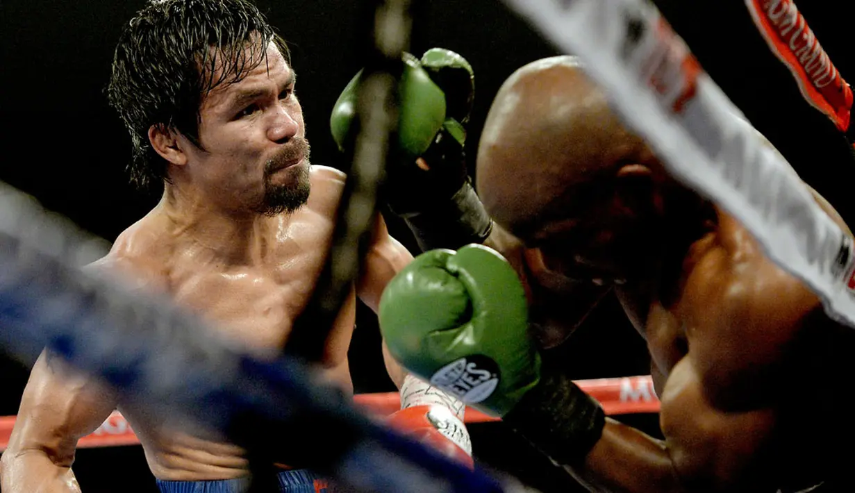 Manny Pacquiao (kiri) terus menyerang Timothy Bradley Jr dalam perebutan gelar juara dunia kelas Walter WBO di MGM Grand Garden Arena, Minggu (13/4/2014). (REUTERS/Jayne Kamin-Oncea-USA TODAY)