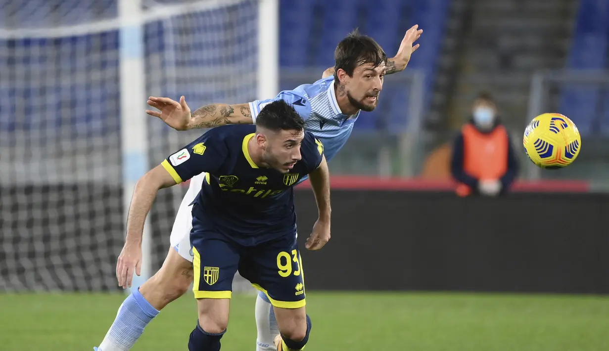 Bek Lazio, Francesco Acerbi berebut bola dengan gelandang Parma, Mattia Sprocati pada pertandingan babak 16 besar Coppa Italia di Stadion Olimpiade Roma di Roma, Italia, Jumat (22/1/2021). Lazio menang atas Parma 2-1. (Alfredo Falcone/LaPresse via AP)