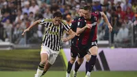 Pemain Juventus, Federico Chiesa mencoba melewati pemain Bologna pada pertandingan Serie A 2023/2024 di Allianz Stadium, Turin, Senin (28/8/2023) dini hari WIB. (Marco Alpozzi/LaPresse via AP)