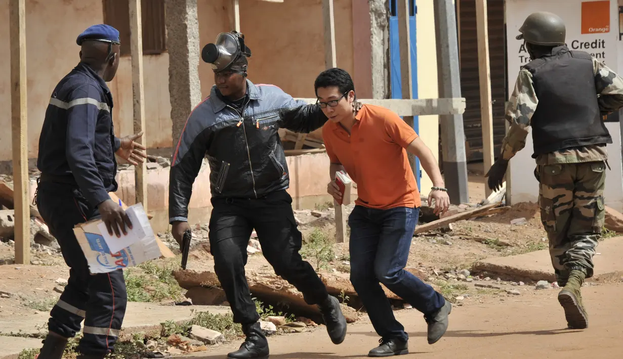 Petugas mengevakuasi sandera yang berhasil diselamatkan dari Hotel Radisson Blu di Bamako, Mali, Jumat (20/11). Kelompok militan Islam menyerbu hotel mewah tersebut dan  menyandera lebih dari 100 orang tamu serta staf hotel. (AFP PHOTO/Habibou Kouyate)