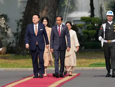 Presiden Korea Selatan Yoon Suk Yeol (tengah kiri) dan istrinya Kim Keon Hee (belakang kiri) berjalan bersama Presiden Republik Indonesia Joko Widodo atau Jokowi (tengah kanan) dan istrinya Iriana (belakang kanan) setibanya untuk pertemuan mereka di Istana Merdeka, Jakarta, Indonesia, Jumat (8/9/2023). (AP Photo/Achmad Ibrahim)