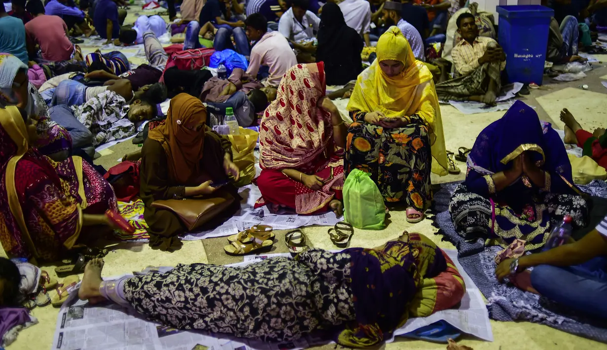 Calon pembeli menunggu dibukanya loket tiket mudik lebaran di Stasiun Kereta Kamalapur, Dhaka, Minggu (3/7). Pemudik Bangladesh rela antre berjam-jam dan bahkan menunggu jauh hari sebelum pembukaan loket tiket. (AFP PHOTO/MUNIR UZ ZAMAN)