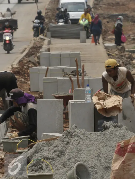  Pekerja saat menyelesaikan proyek rehabilitasi ruas jalan Ciputat-Pamulang, Tangerang Selatan, (28/1). Pemerintah Provinsi Banten akan melakukan rehab pada beberapa titik ruas jalan yang menghabiskan lebih dari Rp 21 miliar. (Liputan6.com/Faisal R Syam)