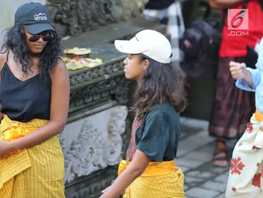 Dua putri Presiden ke-44 AS Barack Obama, Malia dan Sasha, mengunjungi Pura Tirta Empul, Tampaksiring, Gianyar, Bali, Selasa (27/6). Di pura bersejarah tersebut kedua putri Obama kompak mengenakan sarung warna kuning.  (Liputan6.com/Immanuel Antonius)