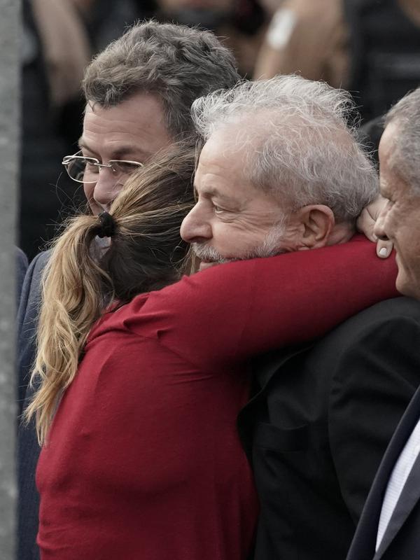 Mantan Presiden Brasil Luiz Inacio Lula da Silva dipeluk putrinya Lurian Cordeiro da Silva ketika ia keluar dari markas Polisi Federal di Curitiba, Brasil (8/11/2019). Lula adalah satu dari ribuan napi yang diuntungkan dari putusan tersebut. (AP Photo/Leo Correa)