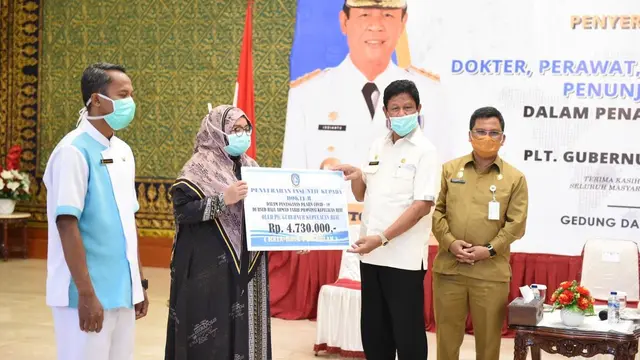 Pelaksana Tugas (Plt) Gubernur Kepri Isdianto menyerahkan insentif kepada dokter, perawat, tenaga kesehatan di Gedung Daerah, Tanjungpinang, Senin (30/3/2020). (Ajang/Liputan6.com)